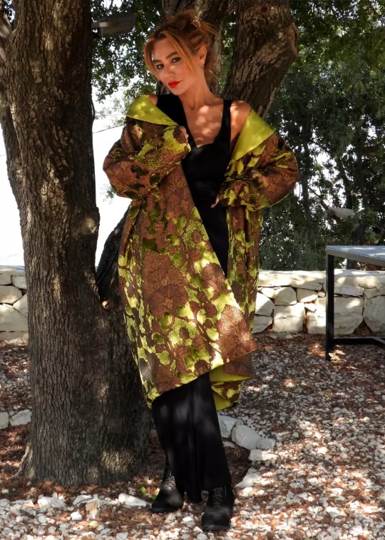 Roula Harb — Olive Brocade Coat, full front by the tree